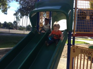 Austin and Aya ride down the slide together 